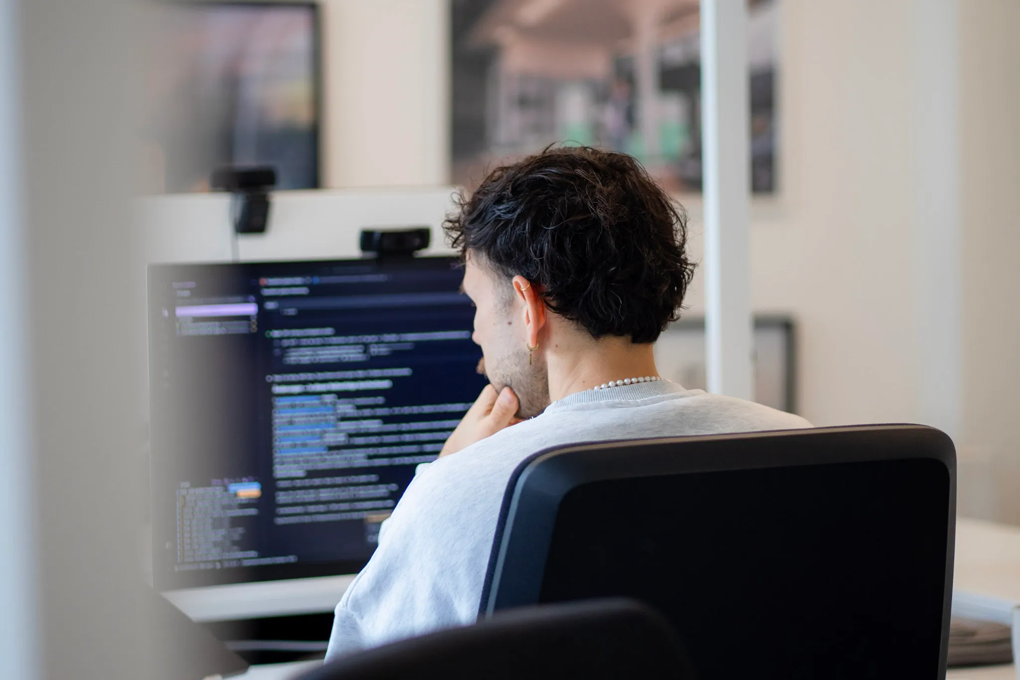 Entwickler arbeitet konzentriert am Code auf seinem Bildschirm